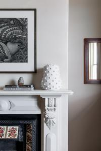 a cake is sitting on top of a fireplace at Belstone cottage - 1880’s terrace at French Street in Launceston