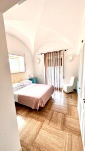 sypialnia z łóżkiem i drewnianą podłogą w obiekcie Villa La Zagara by CapriRooms w mieście Capri