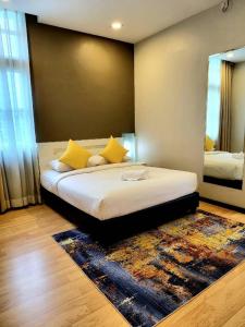 a bedroom with a bed with yellow pillows and a mirror at Lovita Hotel Kuantan in Kuantan