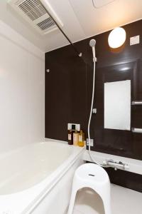 ein Bad mit einem weißen WC in einem Zimmer in der Unterkunft Healing Inn Osaka Fukushima in Osaka + 37 Fotos