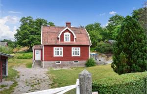 uma casa vermelha com um telhado vermelho em Nice Home In Brkne-hoby With 3 Bedrooms, Sauna And Wifi em Bräkne-Hoby