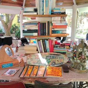 a table with books and a statue of a car on it at Kokrobite Gardens Restaurant and Guest House in Kokrobite