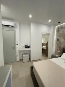 a white bedroom with a bed and a desk at Bullerjanos in Olbia