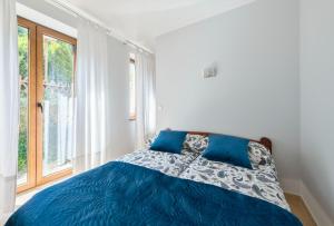 a bedroom with a blue bed and a window at Pokoje Gościnne Marzena in Gdynia
