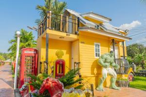 a yellow house with two red telephone booths in front of it at Apinya Resort Bangsarey in Ban Tao Than