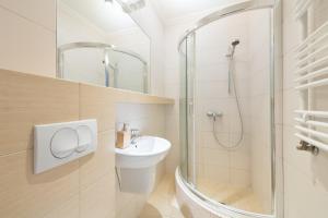 a white bathroom with a sink and a shower at Pokoje Gościnne Marzena in Gdynia