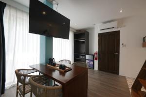 uma sala de estar com uma mesa com cadeiras e uma televisão em J Boutique Hotel El Nido Managed by H Hospitality Group em El Nido mais 37 fotografias