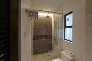 uma casa de banho com um chuveiro e um WC. em J Boutique Hotel El Nido em El Nido