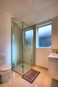 a bathroom with a shower with a toilet and a window at Cambridge Modern 4 Bedrooms House in Cambridge