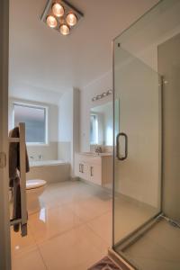 a bathroom with a glass shower and a toilet at Cambridge Modern 4 Bedrooms House in Cambridge