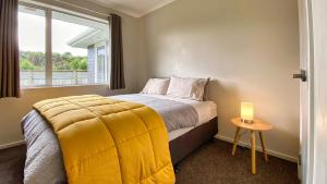 a bedroom with a bed with a yellow blanket on it at Cambridge Modern 4 Bedrooms House in Cambridge