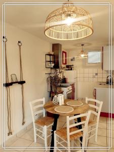 a kitchen with a table and chairs in a room at APPART HOTEL Place des Jolis Rêves in Riom-ès-Montagnes +75 photos