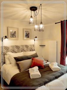 a bedroom with a bed with two towels on it at APPART HOTEL Place des Jolis Rêves in Riom-ès-Montagnes