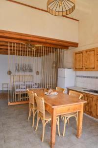 a kitchen with a wooden table and chairs at Boucaporta Sirma Klima in Klima