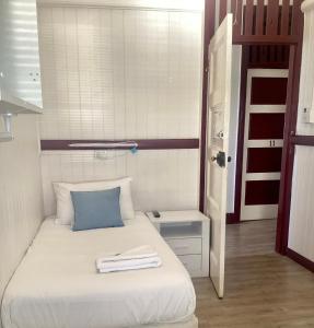 ギンピーにあるThe Australian Hotelの小さなベッドルーム(青い枕付きのベッド付)