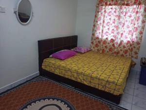 uma cama com duas almofadas num quarto em Homestay Tokwan Besar & Selesa! em Batu Kikir