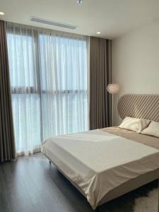 een slaapkamer met een groot bed en grote ramen bij Shin's Conner- 1 bedroom apartment 50m2 at Vinhomes Ocean Park in Hanoi
