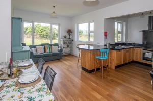 cocina y sala de estar con mesa y sillas en Clonea Beach Houses en Dungarvan