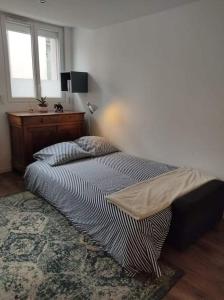 a bedroom with a bed and a desk and a window at HYPERCENTRE, agréable T2 style LOFT , FIBRE in Grenoble