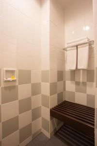 y baño con ducha alicatada y banco. en Bintang Flores Hotel, en Labuan Bajo