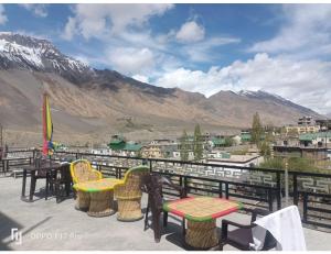 a balcony with tables and chairs and a view of mountains at Hotel Himalayan Hermitage, Kaza in Kaza
