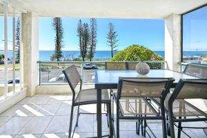 un tavolo e sedie su un balcone con vista sull'oceano di Beachfront Choices Choices Choices ad Alexandra Headland
