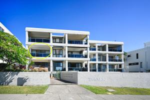a large white apartment building with a yellow circle on it at Beachfront Choices Choices Choices in Alexandra Headland