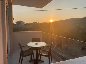 a table and chairs on a balcony with a sunset at Green Memories in Skala Sotiros