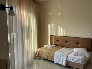 1 dormitorio con 1 cama con cabecero y cortinas en Green Memories, en Skala Sotiros