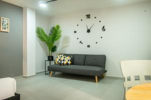 salon z kanapą i zegarem na ścianie w obiekcie Barcelo Coliving w mieście Medellín