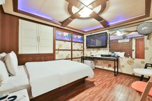 sypialnia z dużym białym łóżkiem i telewizorem w obiekcie Picasso Motel w Seulu