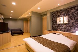 une chambre d'hôtel avec un lit et une télévision dans l'établissement ホテルあかり, à Numazu