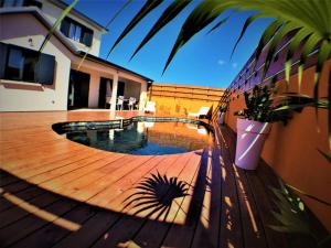 a wooden deck with a swimming pool on a house at Magnifique villa 8 personnes avec piscine au sel in Saint-Pierre