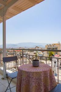 uma mesa e cadeiras numa varanda com vista em Beautiful Loft Ilion em Atenas