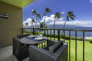 balcón con mesa, sillas y vistas al océano en Maalaea Banyans 217 condo, en Wailuku