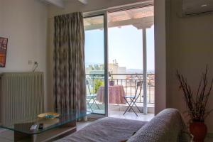 ein Wohnzimmer mit einem Sofa und einem Glastisch in der Unterkunft Beautiful Loft Ilion in Athen
