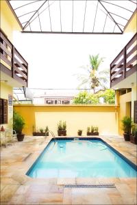 a pool in the middle of a building at Pousada Solarium UNIDADE 1 ECONOMICA-BÁSICA in Guarujá