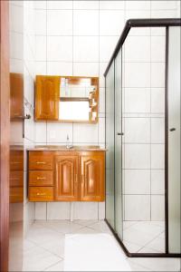 La salle de bains est pourvue d'un lavabo et d'une douche. dans l'établissement Pousada Solarium UNIDADE 1 ECONOMICA-BÁSICA, à Guarujá