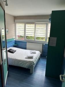 Pokój szpitalny z łóżkiem i dwoma oknami w obiekcie Hôte de la Plage w mieście Dunkierka