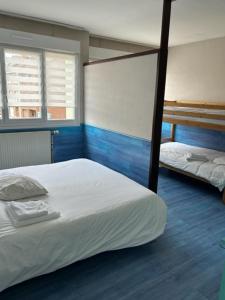 a bedroom with two bunk beds and blue floors at Hôte de la Plage in Dunkerque