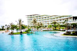 a swimming pool in front of a large building at Villa FLC Sam Son Lavender in Sầm Sơn
