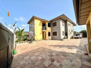 een huis met een stenen oprit ervoor bij Hidden Gem In Oyibi New 2 Luxury Bedroom Apartment in Aburi