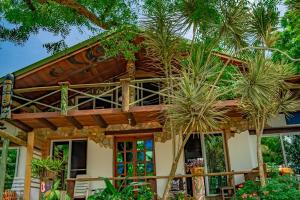 a house with palm trees in front of it at Kokrobite Gardens Restaurant and Guest House in Kokrobite