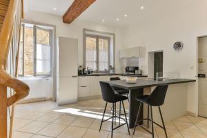 a kitchen with a black table and black chairs at Beau Duplex avec jardin et vue in Lyon