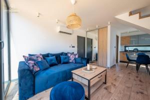 salon z niebieską kanapą i stołem w obiekcie Baltic Houses domki apartamentowe nad morzem przy plaży w mieście Kopań
