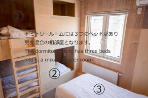 a room with two bunk beds and a window at BEACH AND FIELD INN in Sapporo