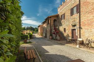 an empty alley with a bench in front of a building at Fattoria Di Pancole in San Gimignano