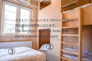 a bedroom with a bunk bed and a book shelf at BEACH AND FIELD INN in Sapporo