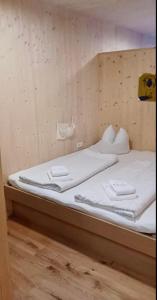 a bed with white sheets and towels on it at Apartment Eiler - Mellau in Mellau