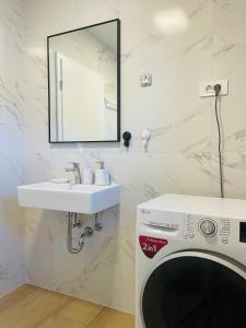ブロダリツァにあるApartment Happyの洗濯機と洗面台を備えたバスルーム